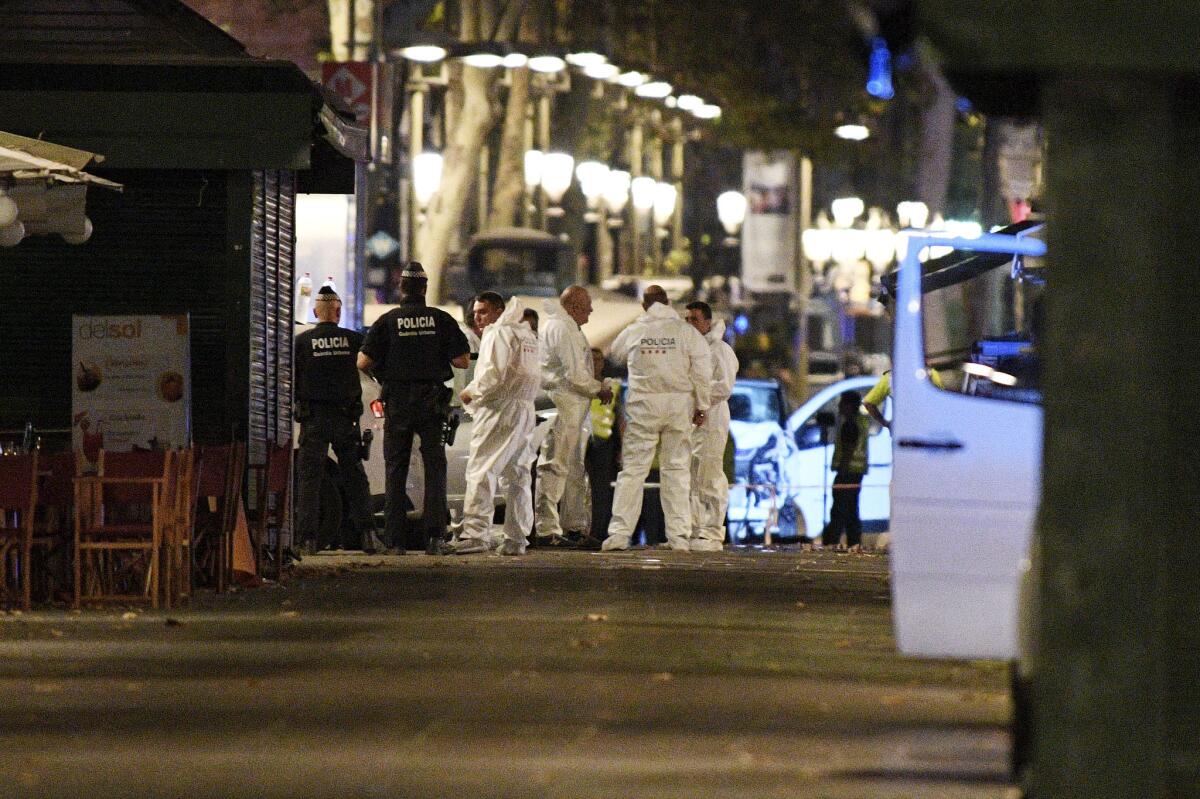 A damaged van, believed to be the one used in the attack, is surrounded forensics officers in Barcelona, Spain.