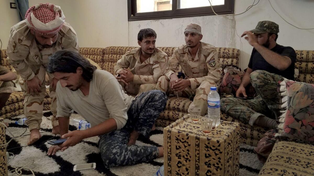 Abu Imad, left, a spokesman in the Free Syrian Army allied with U.S.-backed forces, consults fighters at their base in an abandoned house in east Raqqah before heading to the front line earlier this month.