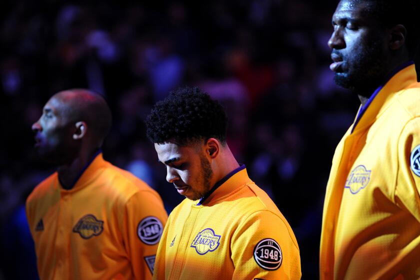 Lakers rookie D'Angelo Russell, center, listens to the national anthem between Kobe Bryant and Roy Hibbert before their game Wednesday night at the Staples Center.
