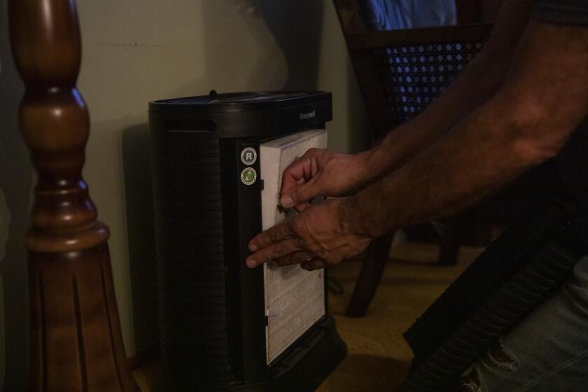 Imperial Beach, California - October 04: Manuel Andrade, 58, shows the filter of an air purifier on Wednesday, Oct. 4, 2023 in Imperial Beach, California. The Andrades, like many South County residents, have complained for years about the odors that lingers in the area that's caused by Tijuana sewage spilling over the border. The family have three air purifiers in their home and leaves the windows shut to keep out the small despite not having air conditioning. Manuel Andrade left his job to become a full-time care giver of his 97-year-old father after promising his mother on her death bed that he wouldn't put his father in a retirement facility. Louis Andrade has lived in his house since the 60s and doesn't know another home. "I could go back to my career and leave him alone," Manuel Andrade said. "Either I go and make money and pay for his care or actively participate in his care." (Ana Ramirez / The San Diego Union-Tribune)