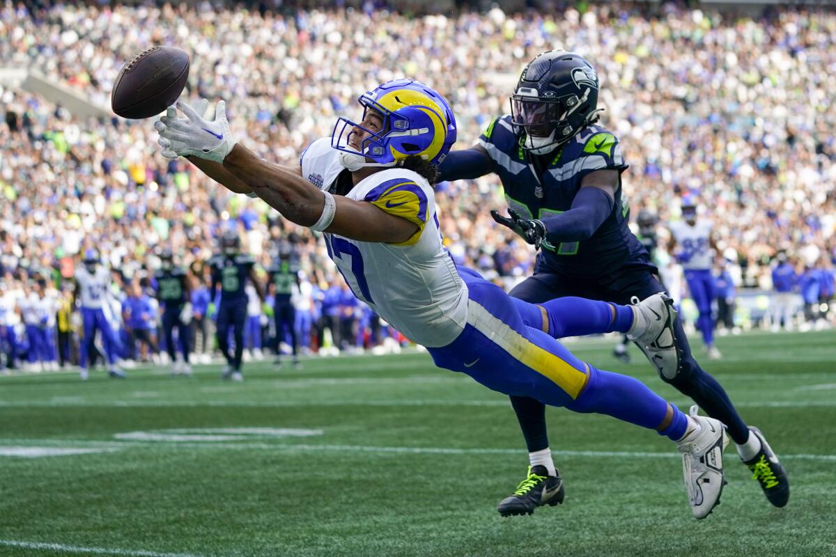 Rams wide receiver Puka Nacua tries to make a diving catch in front of Seattle Seahawks cornerback Riq Woolen.