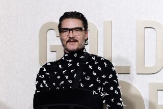 Pedro Pascal in thick eyeglasses in a black mesh shirt with white thread decoration and black pants posing at a red carpet