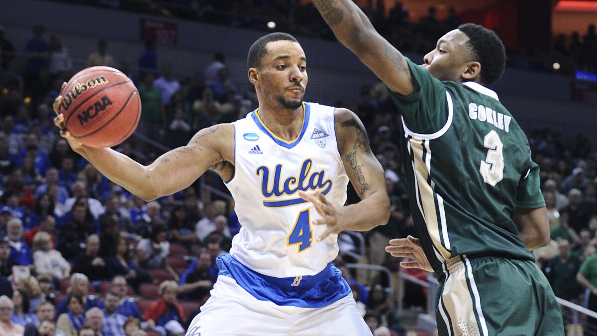 UCLA's Norman Powell, left, passes in front of UAB's Chris Cokley during the Bruins' 92-75 win in the third round of the NCAA tournament South Regional on Saturday.