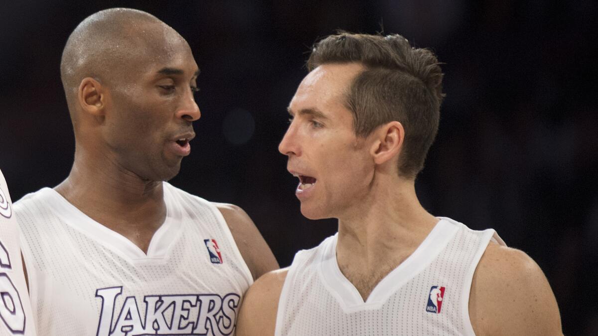 Lakers teammates Kobe Bryant and Steve Nash converse during a game against the New York Knicks on Christmas Day in 2012.