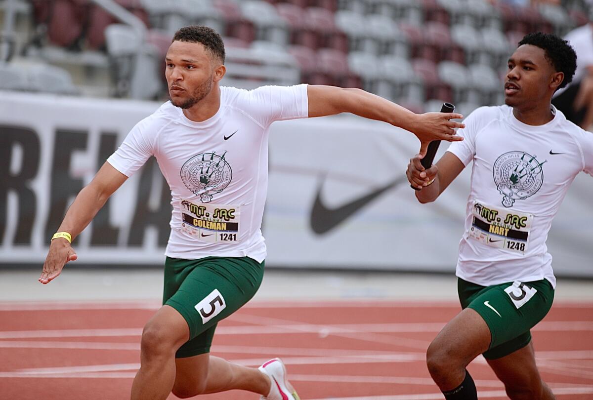 Granada Hills sprinter Jordan Coleman reaches back to receive the baton from teammate Justin Hart last season. 