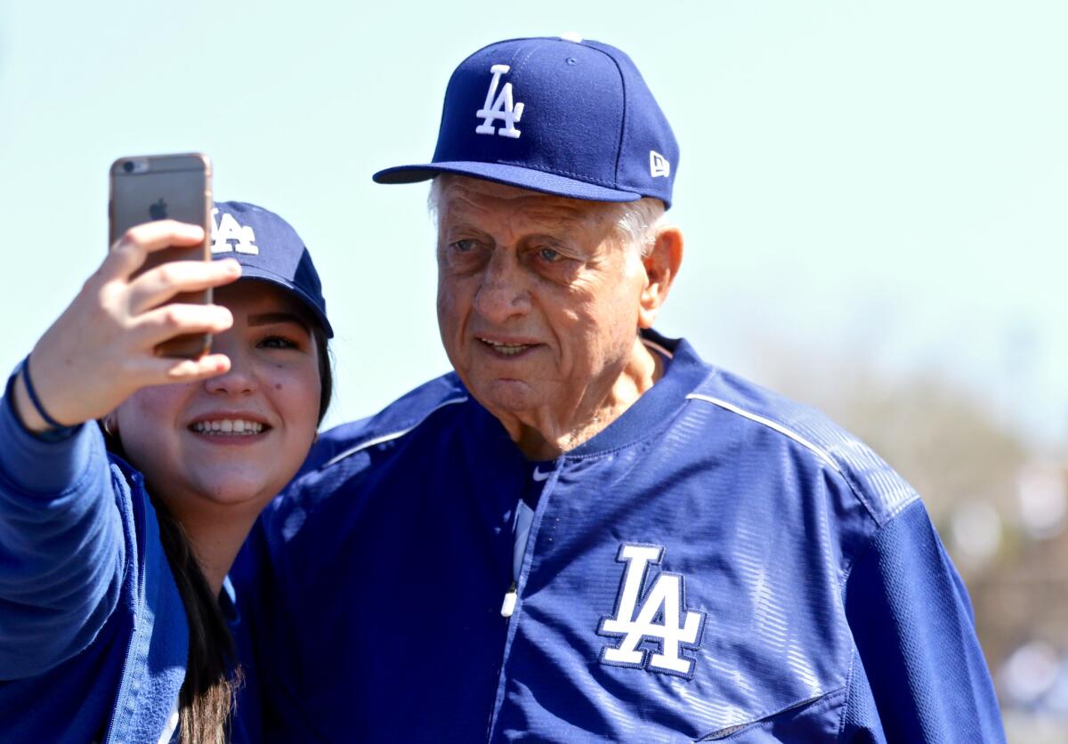 Former Dodgers manager Tommy Lasorda takes a selfie with a fan before a spring training game against the White Sox on Feb. 25.