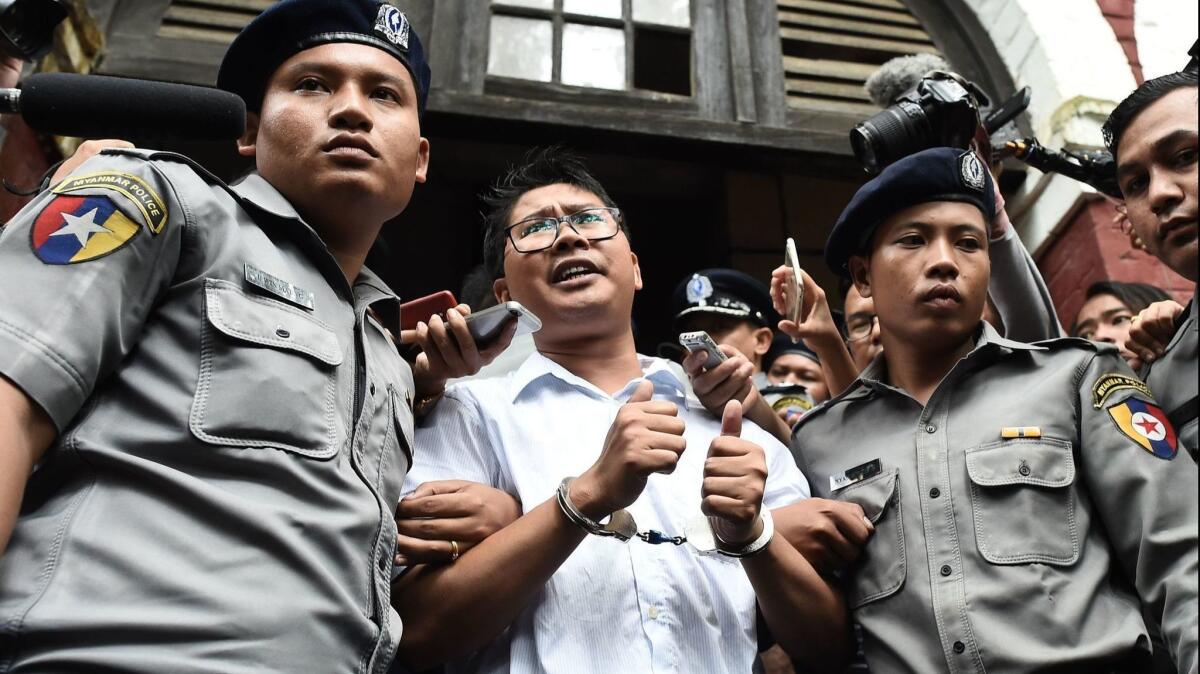 Myanmar journalist Wa Lone, center, speaks to journalists while escorted by police Sept. 3, 2018.