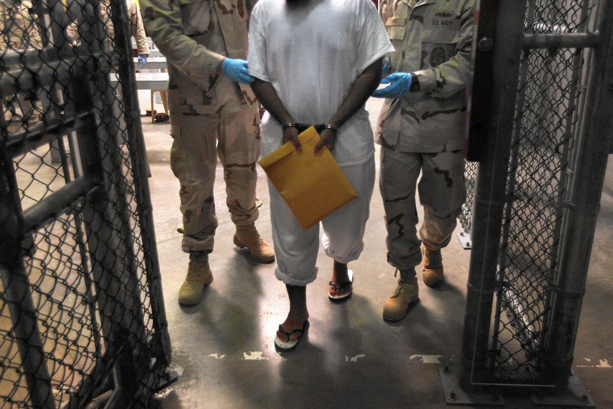 U.S. Navy guards escort a detainee at the Guantanamo Bay naval prison in Cuba.