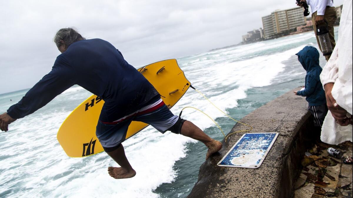Warnings to stay out of the surf did not deter beachgoers at Waikiki Beach as Hurricane Lane neared the Hawaiian islands.