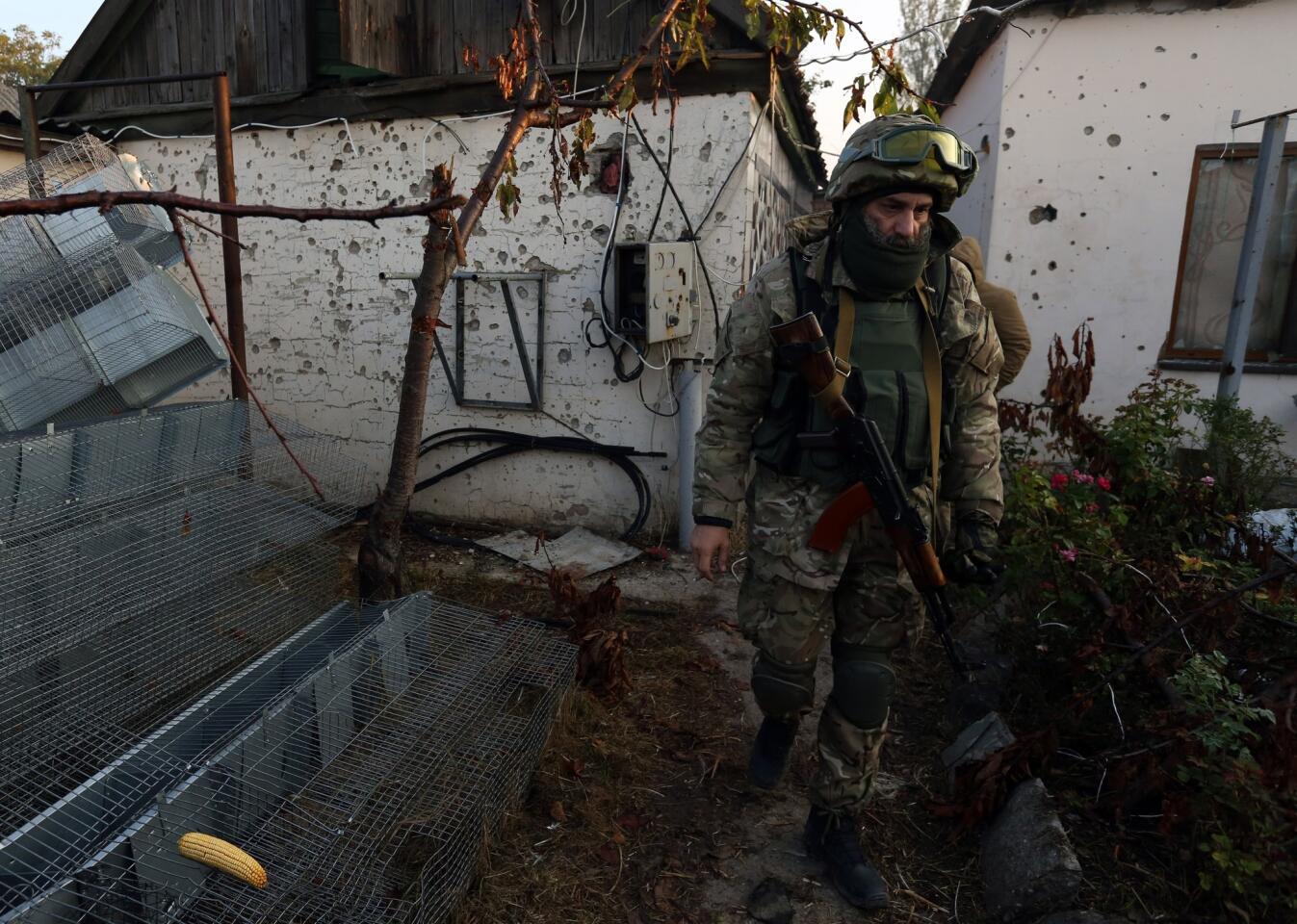 Militia fighter Asher-Jaseph Cherkassky walks in the yard of an abandoned house in the village of Peski on the outskirts of Donetsk, Ukraine.