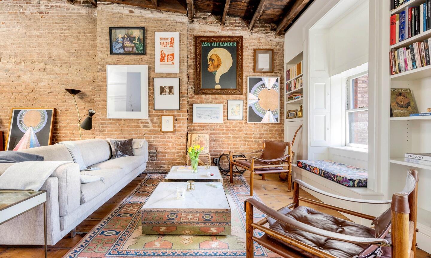 The pre-war penthouse mixes old and new with exposed brick and rustic beams broken up by five skylights.