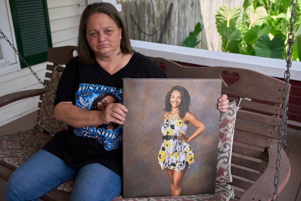 Christy Spivey poses with a portrait of her late daughter Tasia Fortune, Tuesday, Sept. 8, 2026, in Marion, Ky. (AP Photo/George Walker IV)