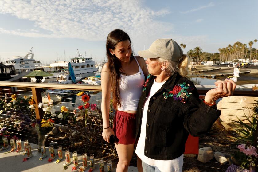 SANTA BARBARA CA SEPTEMBER 3, 2019 -- Olivia, left, (won?t give last name out of respect) sister of a female crew member who died in the boat fire, talks with Jennifer Stafford at a memorial that is growing at the Santa Barbara Harbor where the Conception was based Tuesday morning, September 3, 2019. (Al Seib / Los Angeles Times)