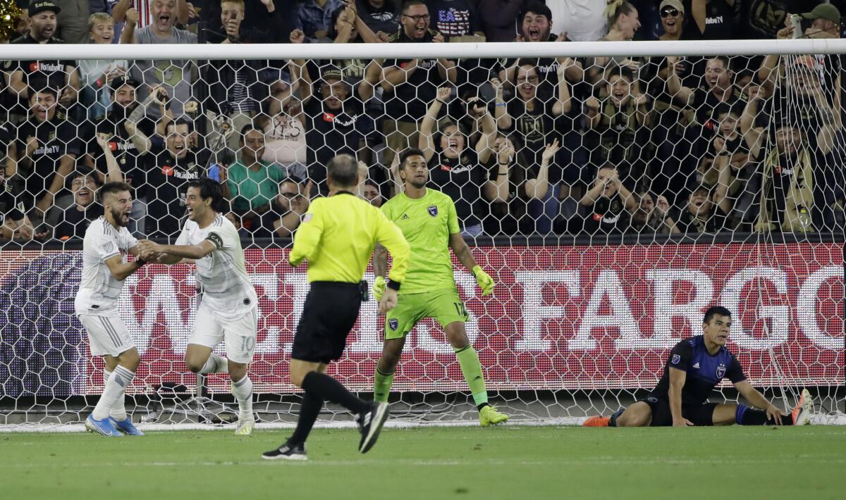 LAFC forward Carlos Vela, second from left, celebrates with teammate Diego Rossi, left, after scoring past San Jose  goalkeeper Daniel Vega and defender Nick Lima.
