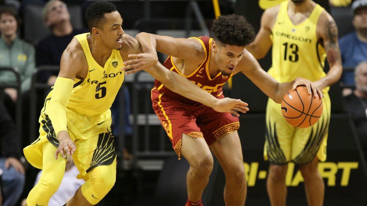 USC's Bennie Boatwright, center, battles Oregon's Elijah Brown for a loose ball as Paul White (13) looks on during a game Jan. 18.