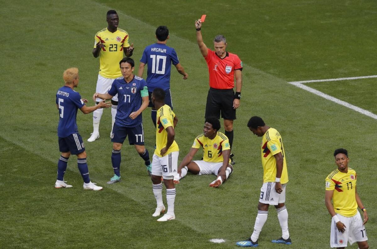 Referee Damir Skomina shows a red card to Colombia's Carlos Sanchez, on the ground, during a Group H match against Japan on June 19.