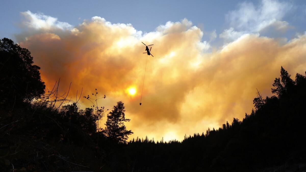 Helicopters drop water along the North Fork of the Feather River outside Pulga, Calif., where the Camp fire may have started.
