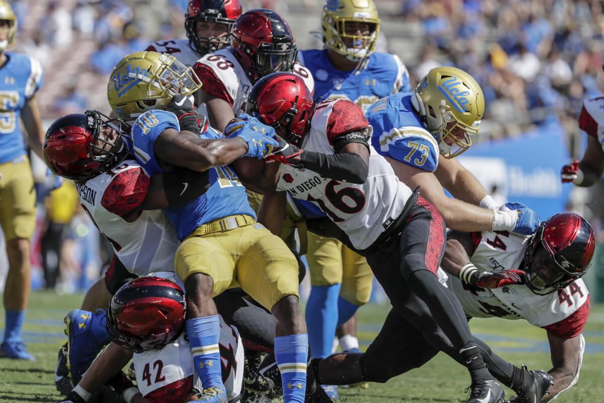 UCLA running back Demetric Felton is gang tackled by San Diego State on Saturday at the Rose Bowl.