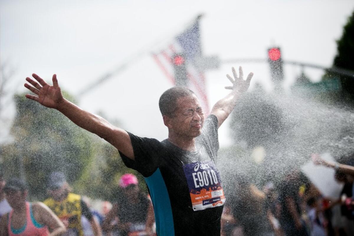 A Los Angeles Marathon runner revels in a cold spray of water at the water station near mile-marker 16 in Beverly Hills on Sunday.