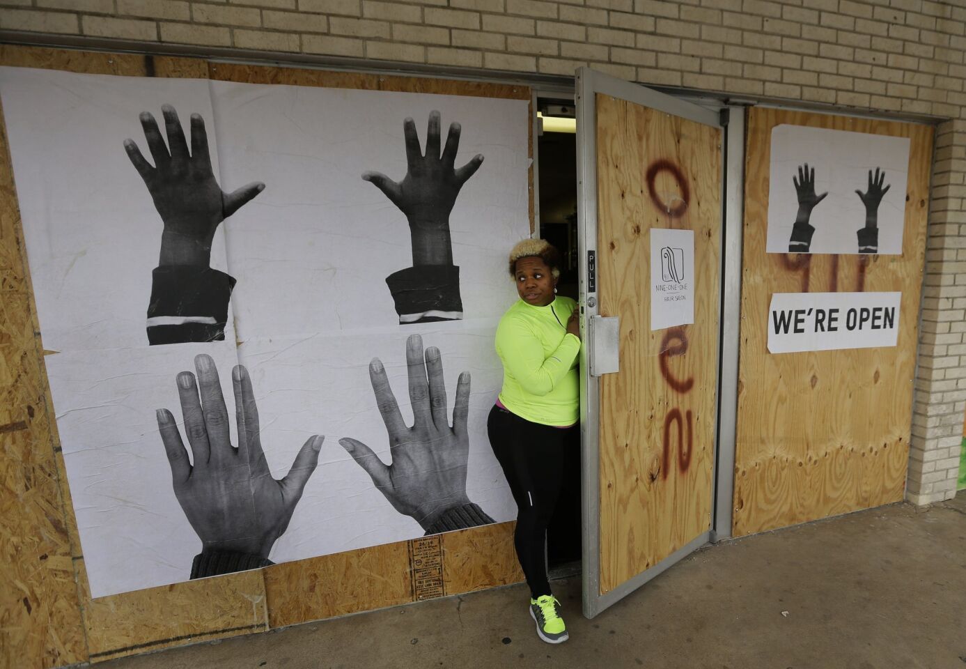 Dellena Jones looks out from her boarded-up beauty salon in the neighborhood where there was much unrest after the August shooting of Michael Brown, 18, by a police officer in Ferguson, Mo.