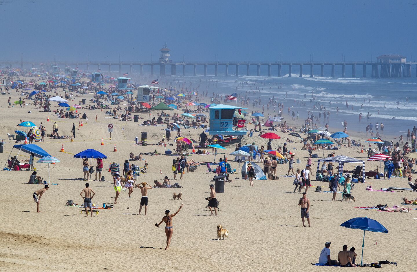 HUNTINGTON BEACH, CA -- SATURDAY, APRIL 25, 2020: Thousands of beach-goers enjoy a warm, sunny day at the beach amid state-mandated stay-at-home and social distancing mandate to stave off the coronavirus pandemic in Huntington Beach, CA, on April 25, 2020. (Allen J. Schaben / Los Angeles Times)