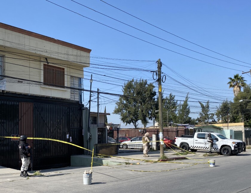 Elements of the National Guard, Tijuana municipal police and Mexico's Army guard a home 