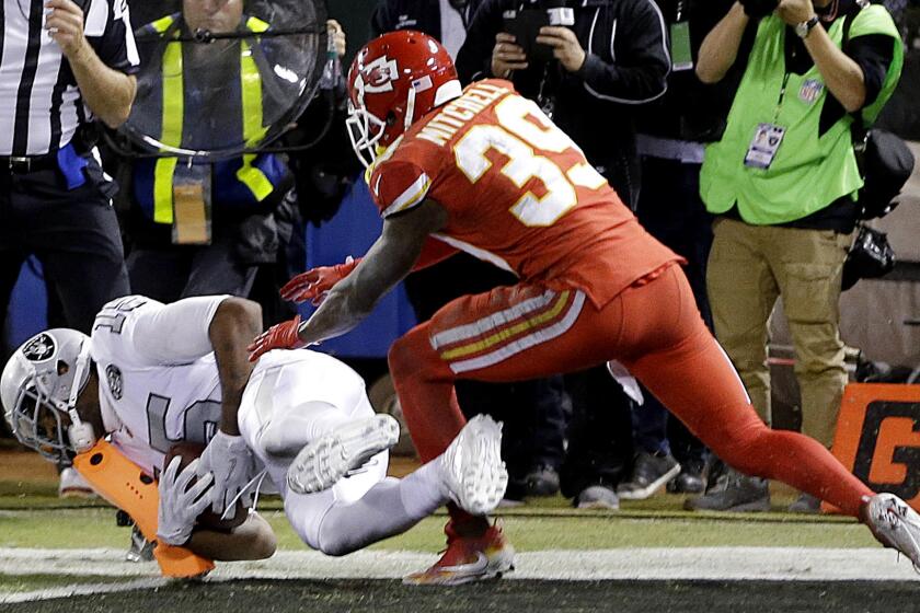 Oakland Raiders wide receiver Michael Crabtree, bottom, catches a touchdown pass in front of Kansas City Chiefs cornerback Terrance Mitchell (39) during the second half of an NFL football game in Oakland, Calif., Thursday, Oct. 19, 2017. (AP Photo/Ben Margot)