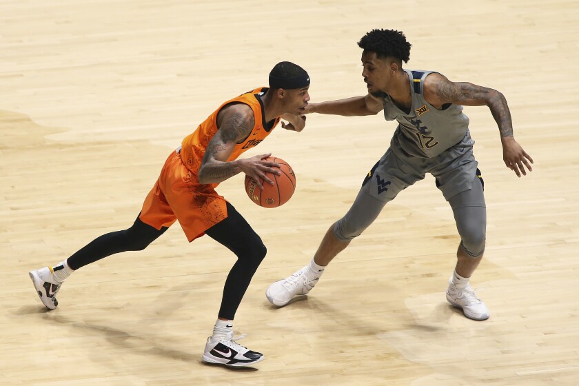 Oklahoma State's Avery Anderson III (0) drives against West Virginia's Taz Sherman on March 6, 2021, in Morgantown, W.Va.
