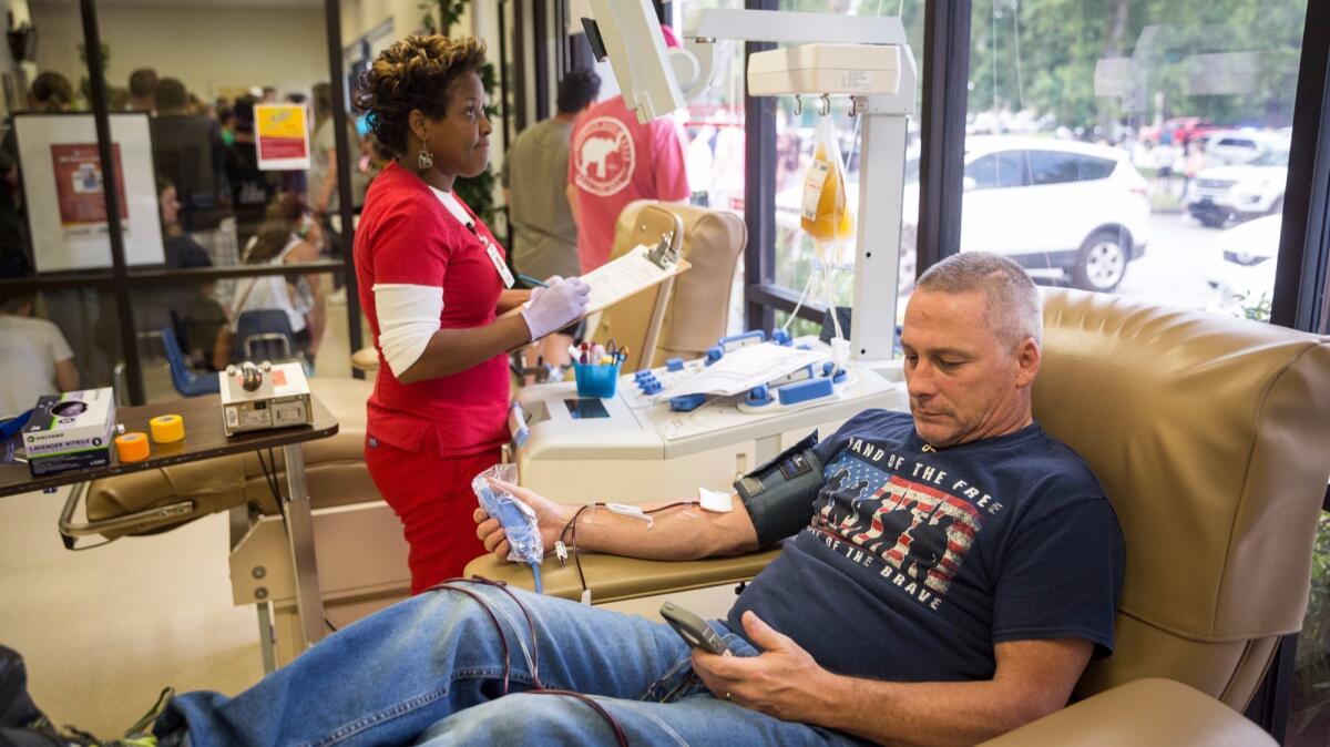 A man donates blood as a phlebotomist stands by at OneBlood Blood Donation Center in Orlando, Fla. on June 12. Early that morning a gunman opened fire inside an Orlando nightclub, killing at least 50 people before dying in a gunfight with SWAT officers.