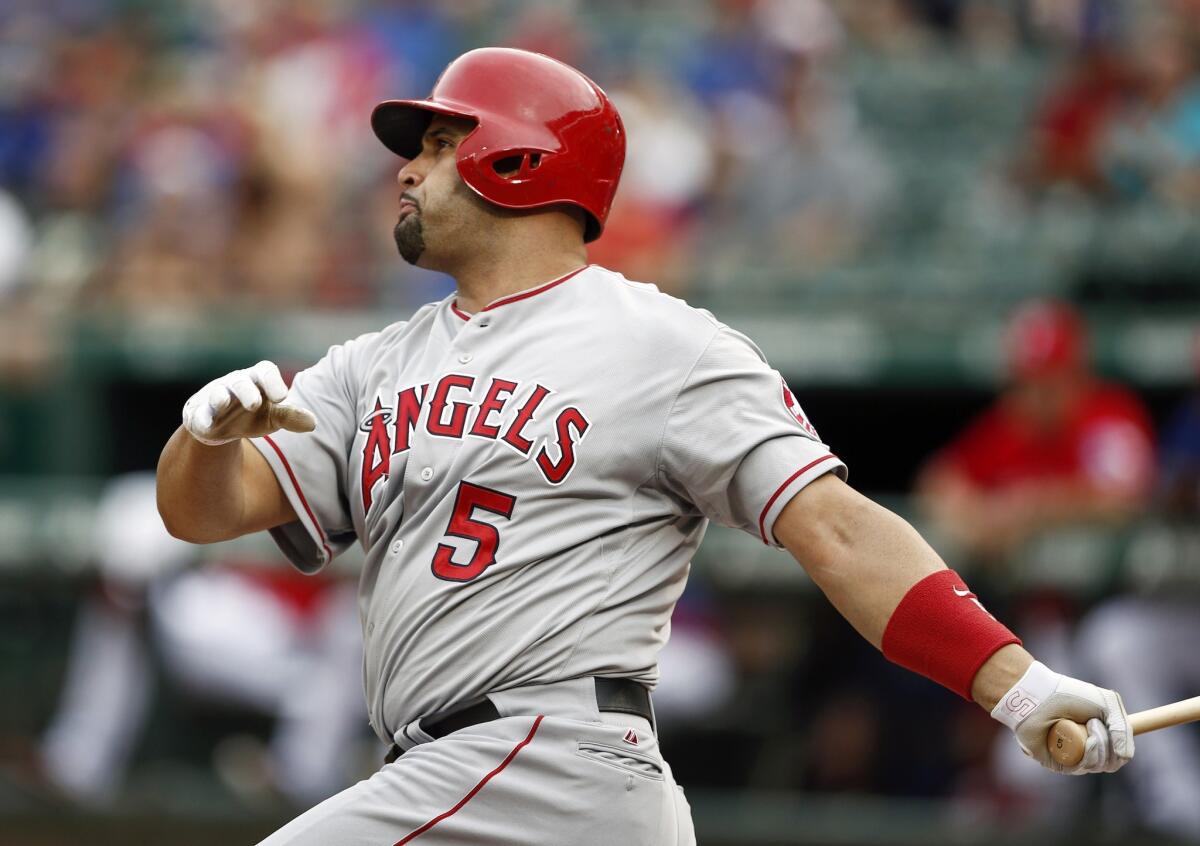 Albert Pujols follows through on a solo home run in the first inning of the Angels' 5-4 win Saturday over the Texas Rangers.