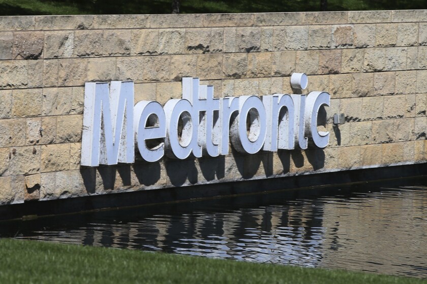 FILE - In this Aug. 29, 2019 file photo, the Medronic logo is reflected in a lake at the company's offices in Fridley, Minn. On Thursday, June 3, 2021, U.S. health regulators warned surgeons to stop implanting an electrical heart pump made by Medtronic due to an electrical problem recently tied to cases of stroke and death. (AP Photo/Jim Mone, File)