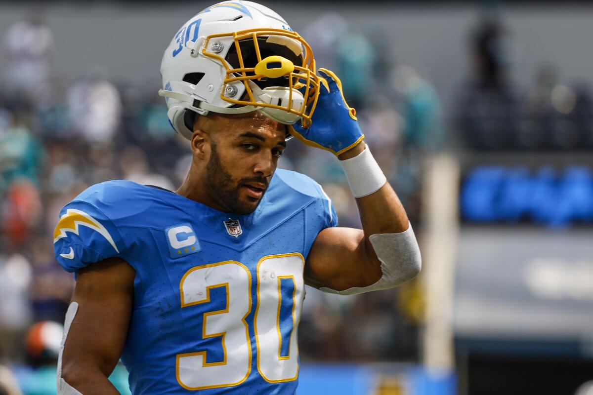 Chargers running back Austin Ekeler takes off his helmet as he reaches the sideline before a game against the Dolphins.
