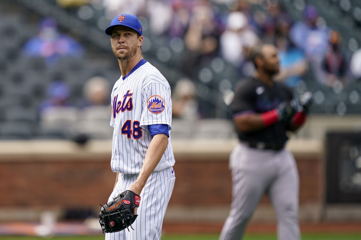 New York Mets starting pitcher Jacob deGrom (48) walks off the field after striking out Miami Marlins' Jesus Aguilar in the first inning of a baseball game, Saturday, April 10, 2021, in New York. (AP Photo/John Minchillo)