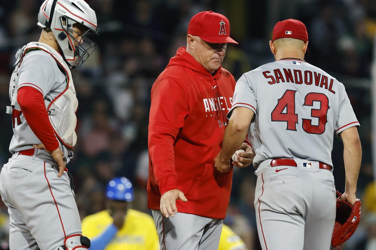 Angels manager Phil Nevin removes pitcher Patrick Sandoval during the fourth inning. Catcher Logan O'Hoppe is at left.