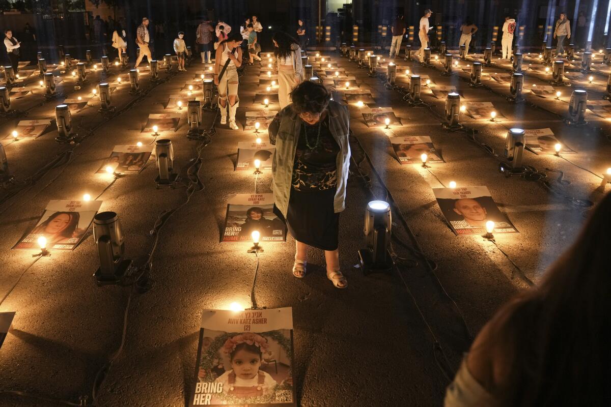 People walk between posters of hostages abducted by Hamas militants