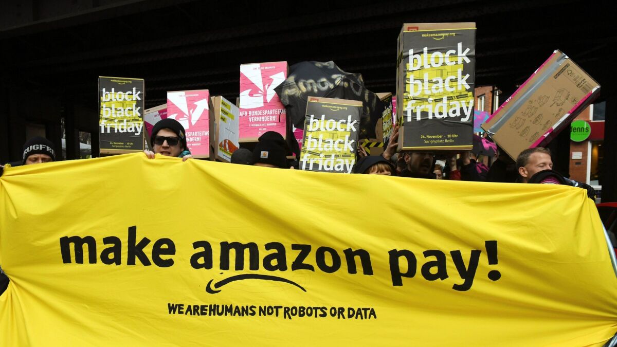 Amazon workers in Berlin hold a banner while staging a strike for better wages on Nov. 24, 2017.