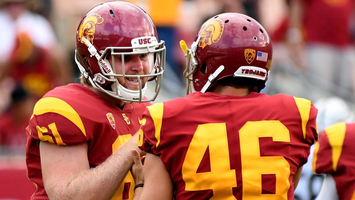 Jake Olson is congratulated by USC teammate Wyatt Schmidt (46) after snapping the ball for an extra point against Western Michigan during the fourth quarter Saturday.