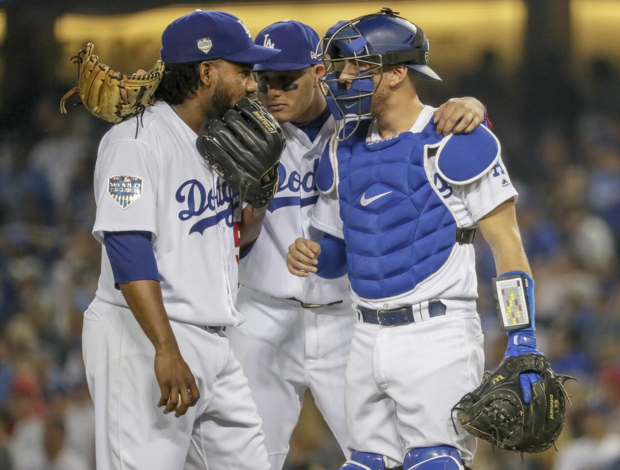 Pedro Baez, Manny Machado and Austin Barnes meet on the mound in the tenth inning.