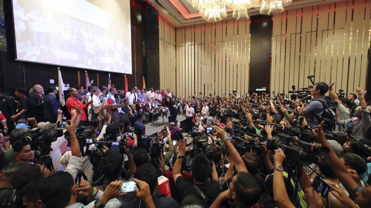 Opposition leader and 92-year-old former autocrat Mahathir Mohamad, center on stage, celebrates victory Wednesday at a hotel in Kuala Lumpur, Malaysia.
