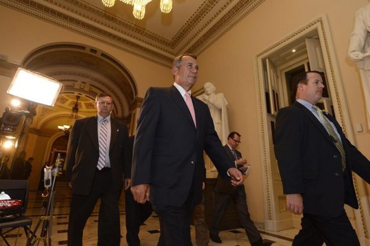Speaker of the House John Boehner, center, is seen leaving the House Chamber. The Senate has so far rejected a House version of the resolution that included language limiting the Affordable Care Act.