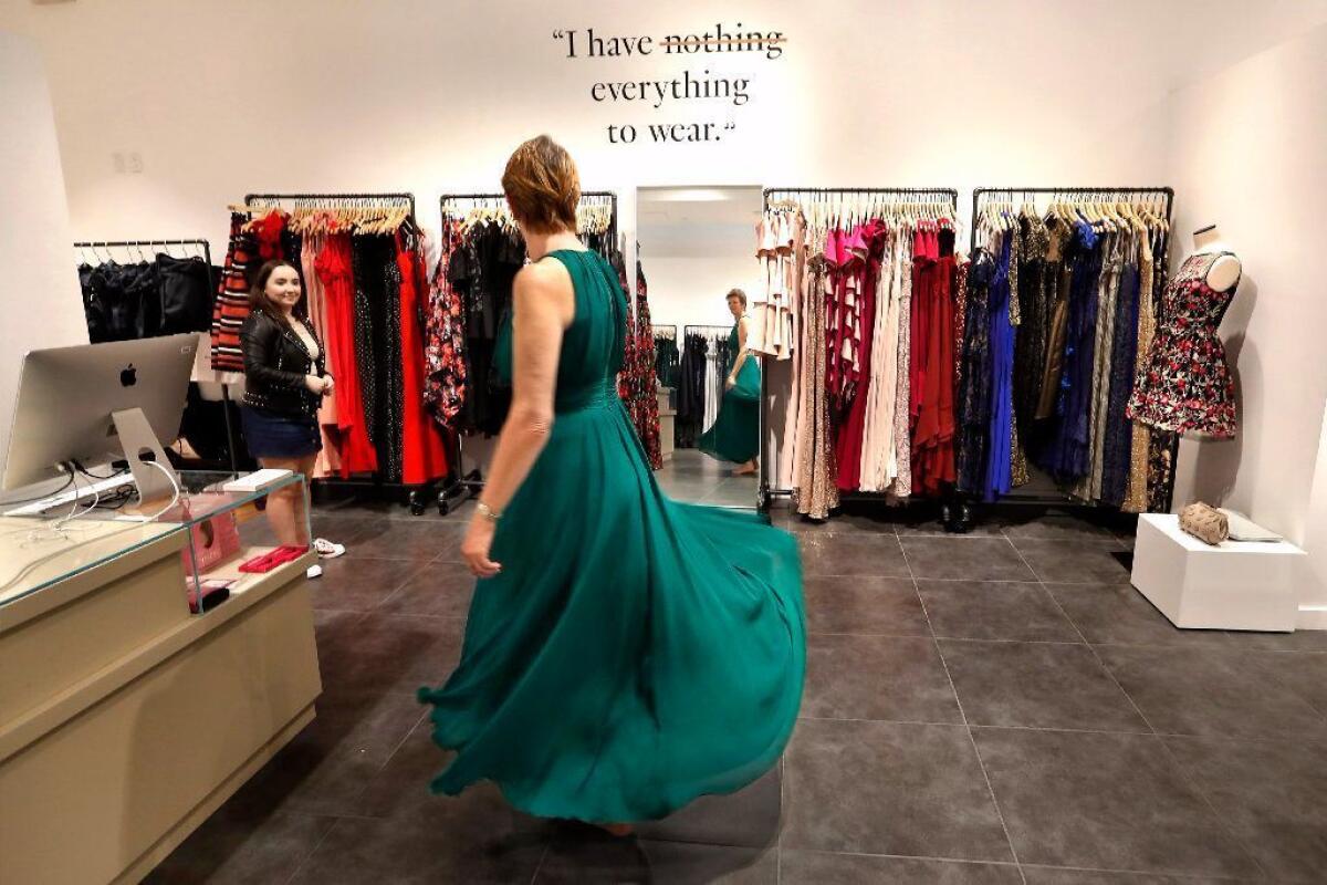 A woman tries on an evening gown in 2017 at a Rent the Runway location.