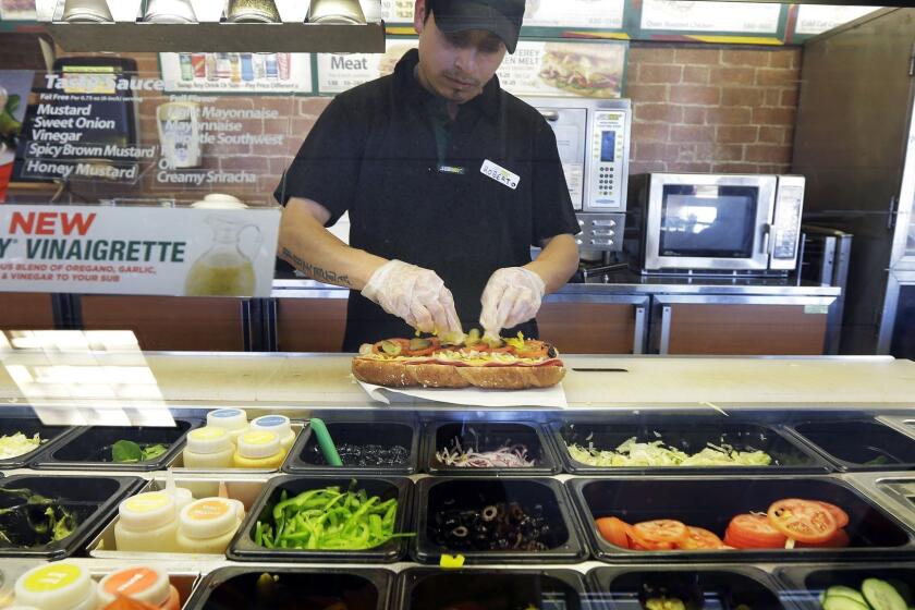 In this March 3, 2015 photo, Roberto Castelan makes a sandwich at a Subway sandwich franchise in Seattle. The sandwich chain known for its marketing itself as a fresher alternative to hamburger chains on Thursday, June 4, 2015 told The Associated Press it will remove artificial flavors, colors and preservatives from its menu in North America by 2017. (AP Photo/Ted S. Warren) ORG XMIT: NYBZ115