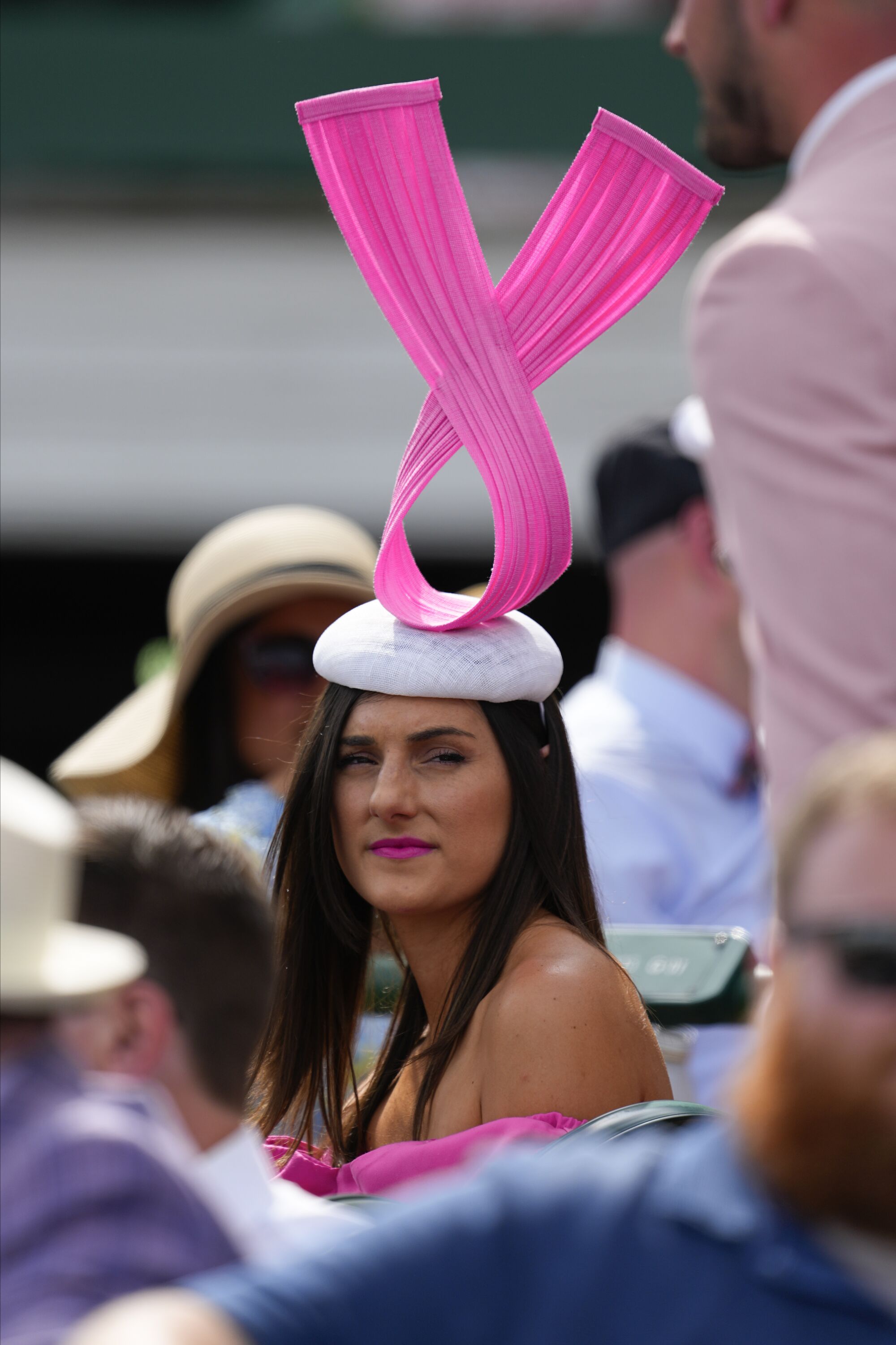 A woman wore a hat that featured an upside-down pink ribbon on the grounds of Churchill Downs.