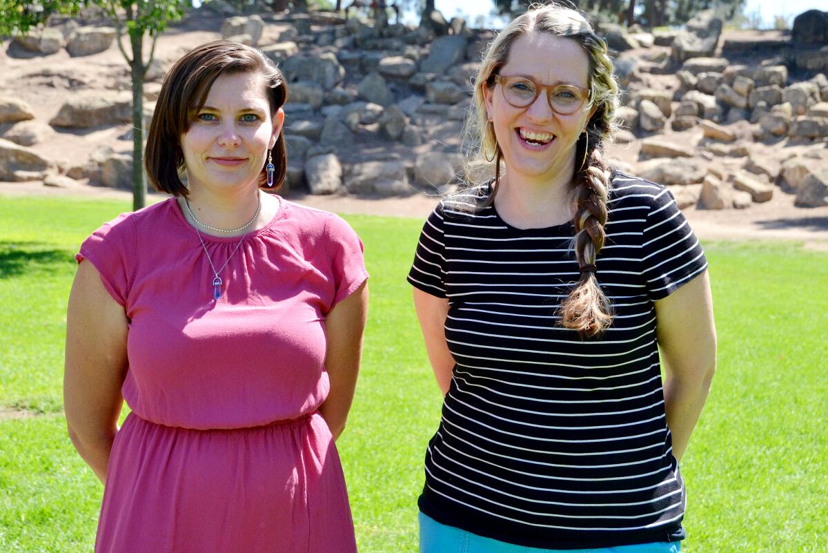 Two woman stand next to each other. 