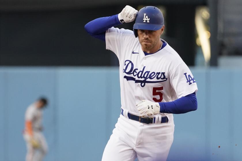 Los Angeles Dodgers' Freddie Freeman taps his helmet as he rounds second base after hitting a solo home run against the San Francisco Giants during the first inning of a baseball game Thursday, July 21, 2022, in Los Angeles. (AP Photo/Marcio Jose Sanchez)