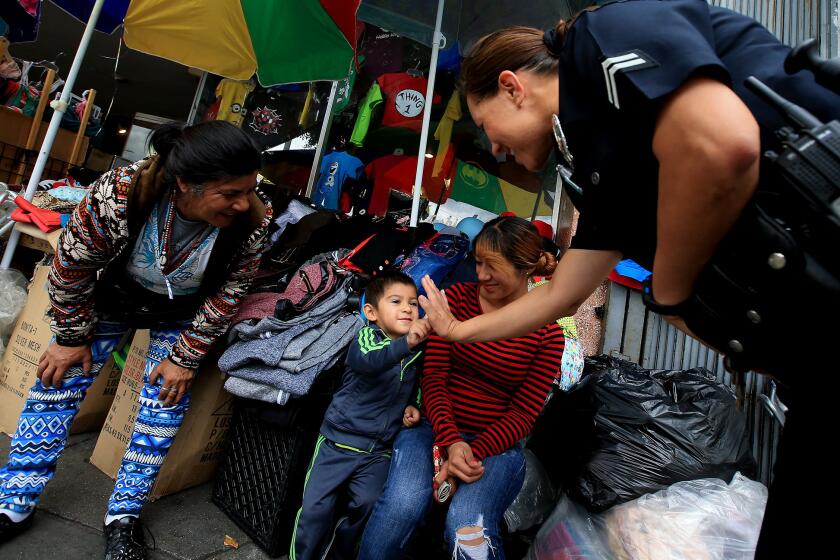 LAPD Officer Norma Perez talks with vendors as she walks a "foot beat" along Cesar Chavez Avenue in Boyle Heights.