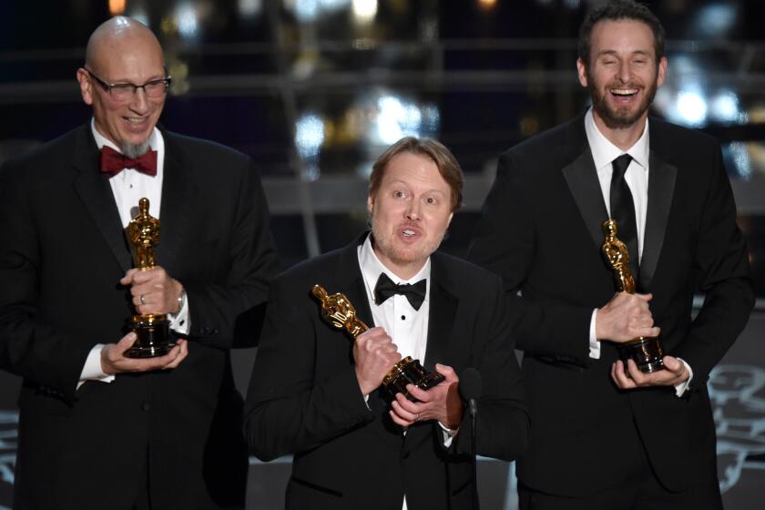 Roy Conli, left, Don Hall and Chris Williams accept the animated feature film Oscar for "Big Hero 6."