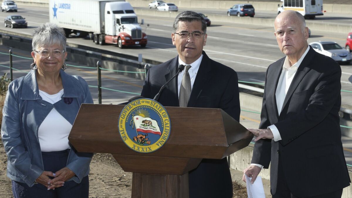 California Air Resources Board Chairwoman Mary Nichols, left, Atty. Gen. Xavier Becerra and then-Gov. Jerry Brown announce they would fight the Trump White House's plan to roll back auto emission rules.