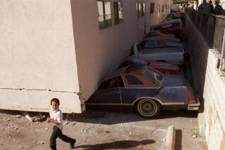 Crushed vehicles at a soft-story apartment building that collapsed during the Northridge earthquake.