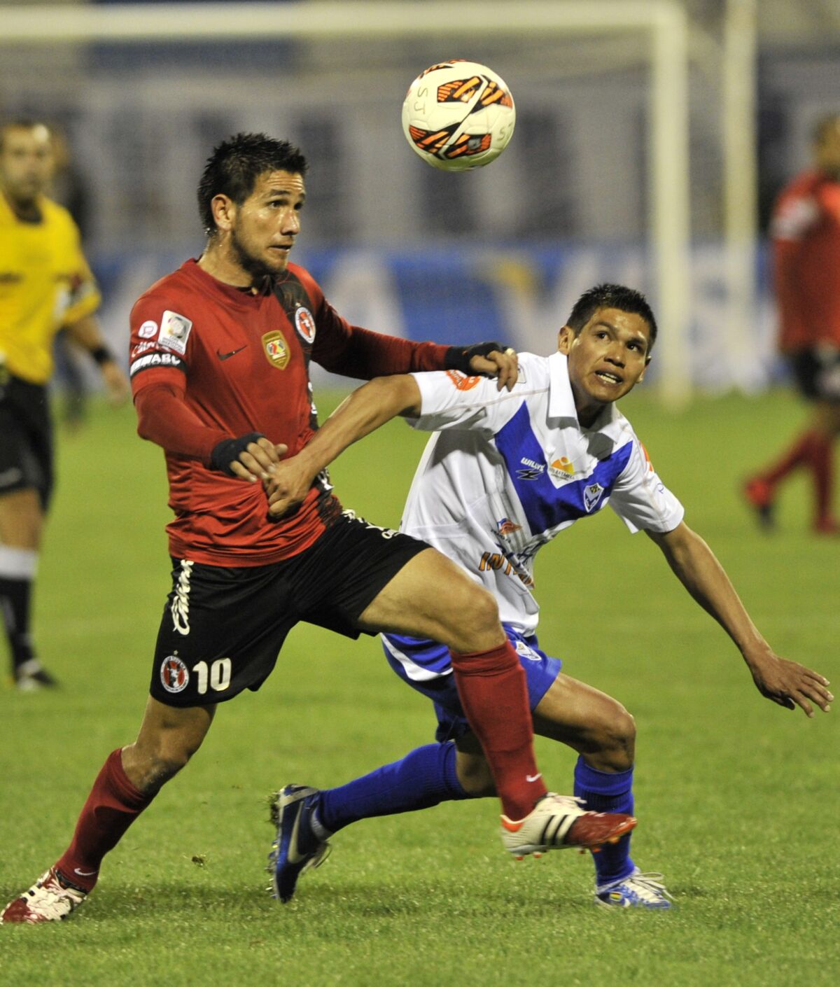 Raúl Enríquez, a la izquierda, del Club Tijuana disputa el balón con Aníbal Torrico del San José de Bolivia